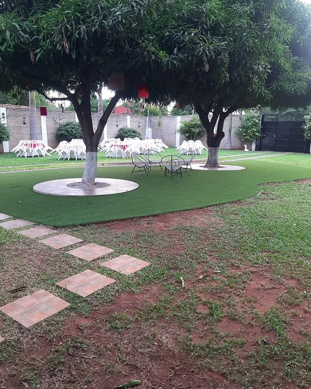 Jardín con árboles y mesas para eventos